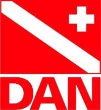 红底白斜杠与十字标志，上方红色背景右上角有白色十字，下方大写红色字母"DAN"。